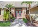 Home's front entrance with double glass doors, brick surround, manicured landscaping, and a stone walkway at 70 Deerpath Dr, Oldsmar, FL 34677