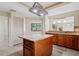 Spacious kitchen with a center island, granite countertops, custom cabinets, and modern lighting fixtures at 70 Deerpath Dr, Oldsmar, FL 34677