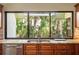 Bright kitchen features a granite countertop, stainless steel sink, and a large window with a garden view at 70 Deerpath Dr, Oldsmar, FL 34677