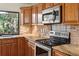 Well-equipped kitchen with stainless steel appliances, custom cabinets, and granite countertops at 70 Deerpath Dr, Oldsmar, FL 34677