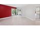 Bright room featuring tile flooring, red accent wall, and sliding doors to the pool at 70 Deerpath Dr, Oldsmar, FL 34677