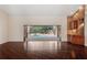 Bright living room with wood floors, a wet bar, and sliding glass doors opening to the pool area at 70 Deerpath Dr, Oldsmar, FL 34677