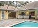 Back patio with an outdoor kitchen area and pool at 70 Deerpath Dr, Oldsmar, FL 34677
