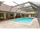 Screened-in pool with adjacent spa, brick surround, sliding glass door access to the home's interior at 70 Deerpath Dr, Oldsmar, FL 34677