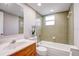 Well-lit bathroom featuring a tub and shower combination with tiled walls and a wooden vanity at 709 Lanewood Dr, Seffner, FL 33584