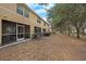 An expansive backyard with screened in patio in a neighborhood with mature trees and a carpet of leaves at 10944 Keys Gate Dr, Riverview, FL 33579