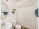 Bright bathroom features a round mirror, two-tiered shelf, toilet, and a linen closet at 10944 Keys Gate Dr, Riverview, FL 33579