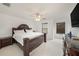This bedroom showcases an ornate, dark wood bed frame, ceiling fan, and lots of natural light at 10944 Keys Gate Dr, Riverview, FL 33579