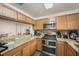 Well-equipped kitchen with wood cabinetry, stainless steel appliances, and granite countertops, creating a functional space at 10944 Keys Gate Dr, Riverview, FL 33579