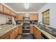 Efficient kitchen features stainless steel appliances, wood cabinets, and granite countertops for a modern touch at 10944 Keys Gate Dr, Riverview, FL 33579
