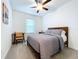 Bedroom featuring a dark-wood bed, a ceiling fan, and neutral decor at 10998 Gable Dig Loop, San Antonio, FL 33576