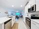 Bright kitchen showcasing white cabinetry, modern stainless steel appliances, and open layout at 10998 Gable Dig Loop, San Antonio, FL 33576