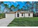 Charming single-story home with manicured lawn and attached two-car garage under a bright blue sky at 11073 Jackdaw Rd, Weeki Wachee, FL 34614