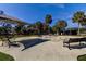 A public park with umbrella-shaded benches and a splash pad on a sunny day at 1208 E Giddens Ave, Tampa, FL 33603