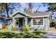 Charming blue home showcasing inviting front porch and mature trees at 1208 E Giddens Ave, Tampa, FL 33603