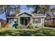 Charming blue home with a well-manicured lawn and inviting front porch at 1208 E Giddens Ave, Tampa, FL 33603
