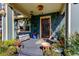 Charming covered front porch adorned with plants and seating at 1208 E Giddens Ave, Tampa, FL 33603
