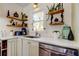 View of kitchen featuring stainless appliances, vintage cabinets and fixtures, and a window over the sink at 1208 E Giddens Ave, Tampa, FL 33603
