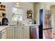 Kitchen area featuring stainless appliances, vintage cabinets and fixtures, and a window over the sink at 1208 E Giddens Ave, Tampa, FL 33603