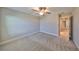 The bedroom provides access to the hall with neutral carpeting and gray walls at 12779 Fisherville Way, Riverview, FL 33579