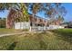 Townhomes line the lake with white fences and lush greenery on a sunny day at 13733 Juniper Blossom Dr, Tampa, FL 33618