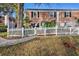 A red brick townhome features a fenced backyard, gate, and a pathway on a sunny day at 13733 Juniper Blossom Dr, Tampa, FL 33618