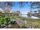 Scenic backyard view with a lake, white picket fence, and lush greenery on a sunny day at 13733 Juniper Blossom Dr, Tampa, FL 33618