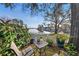 Backyard patio with seating overlooking the water, complete with landscaping, white picket fence, and large shade tree at 13733 Juniper Blossom Dr, Tampa, FL 33618