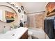 Bathroom featuring tub with tiled walls, shower, white cabinets and vanity, and decorative mirror at 13733 Juniper Blossom Dr, Tampa, FL 33618