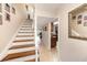Bright foyer featuring stairs with wood treads, tile flooring, and view of kitchen at 13733 Juniper Blossom Dr, Tampa, FL 33618