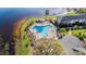 Aerial view of a unique, fenced in community pool surrounded by lounge chairs and lush landscaping on the lake at 13733 Juniper Blossom Dr, Tampa, FL 33618