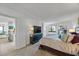 Bright bedroom with a peek into the kitchen, a dresser, and a large window at 1651 Sand Key Estates Ct # 78, Clearwater, FL 33767