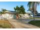 Charming single-story home with lush front yard, decorative shrubs and a cozy bench on the front porch at 2009 Douglas Ave, Dunedin, FL 34698