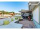 Outdoor patio area with stylish seating, colorful rug, screened porch, a view of a pool, and orange umbrellas at 2009 Douglas Ave, Dunedin, FL 34698