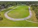 Aerial view of a community green space with walking track and surrounding trees at 23227 Club Villas Dr # 38, Land O Lakes, FL 34639