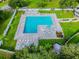 Aerial view of the community pool and lounge area surrounded by lush green landscaping at 23227 Club Villas Dr # 38, Land O Lakes, FL 34639