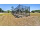 Community batting cage in a grassy field on a sunny day with trees and a clear blue sky at 23227 Club Villas Dr # 38, Land O Lakes, FL 34639