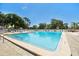 Large community pool with lounge chairs on a sunny day surrounded by mature landscaping at 23227 Club Villas Dr # 38, Land O Lakes, FL 34639