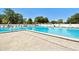 Large community pool with lounge chairs on a sunny day surrounded by mature landscaping at 23227 Club Villas Dr # 38, Land O Lakes, FL 34639