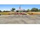 Community clubhouse with well-manicured landscaping, including an American flag at 23227 Club Villas Dr # 38, Land O Lakes, FL 34639