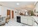 Bright kitchen with white cabinets, tile floor, modern dishwasher, and open view to living area at 23227 Club Villas Dr # 38, Land O Lakes, FL 34639
