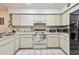 Well-lit kitchen with white cabinets and appliances, plus practical tile flooring at 23227 Club Villas Dr # 38, Land O Lakes, FL 34639
