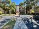 Condo building featuring lush tropical landscaping, a red-tile roof, and a welcoming entrance at 2400 Feather Sound Dr # 1016, Clearwater, FL 33762