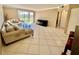 Bright living room featuring a large sofa, sliding doors, and tile flooring at 2400 Feather Sound Dr # 1016, Clearwater, FL 33762