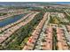 Aerial view of the community with a lake, landscape, and numerous homes with terracotta-colored roofs at 320 Seneca Falls Dr, Apollo Beach, FL 33572