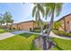 Charming single-story home featuring a lush, well-manicured lawn, and mature palm trees at 320 Seneca Falls Dr, Apollo Beach, FL 33572