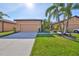 Charming single-story home featuring a lush, well-manicured lawn, and mature palm trees at 320 Seneca Falls Dr, Apollo Beach, FL 33572