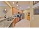 Well-lit kitchen features stainless steel appliances, granite counters, and light wood cabinets at 320 Seneca Falls Dr, Apollo Beach, FL 33572