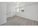 Bright bedroom featuring wood-look floors, white trim, and multiple windows allowing for natural light at 407 Cranberry Ln, Brandon, FL 33510