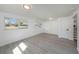 Bright bedroom featuring wood-look floors, white trim, and multiple windows allowing for natural light at 407 Cranberry Ln, Brandon, FL 33510